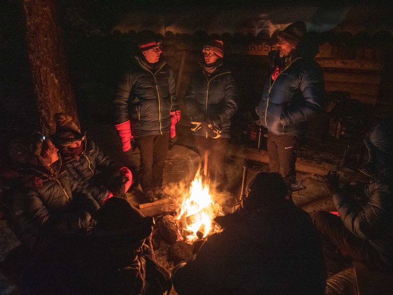 A group of people around a fire

Description automatically generated