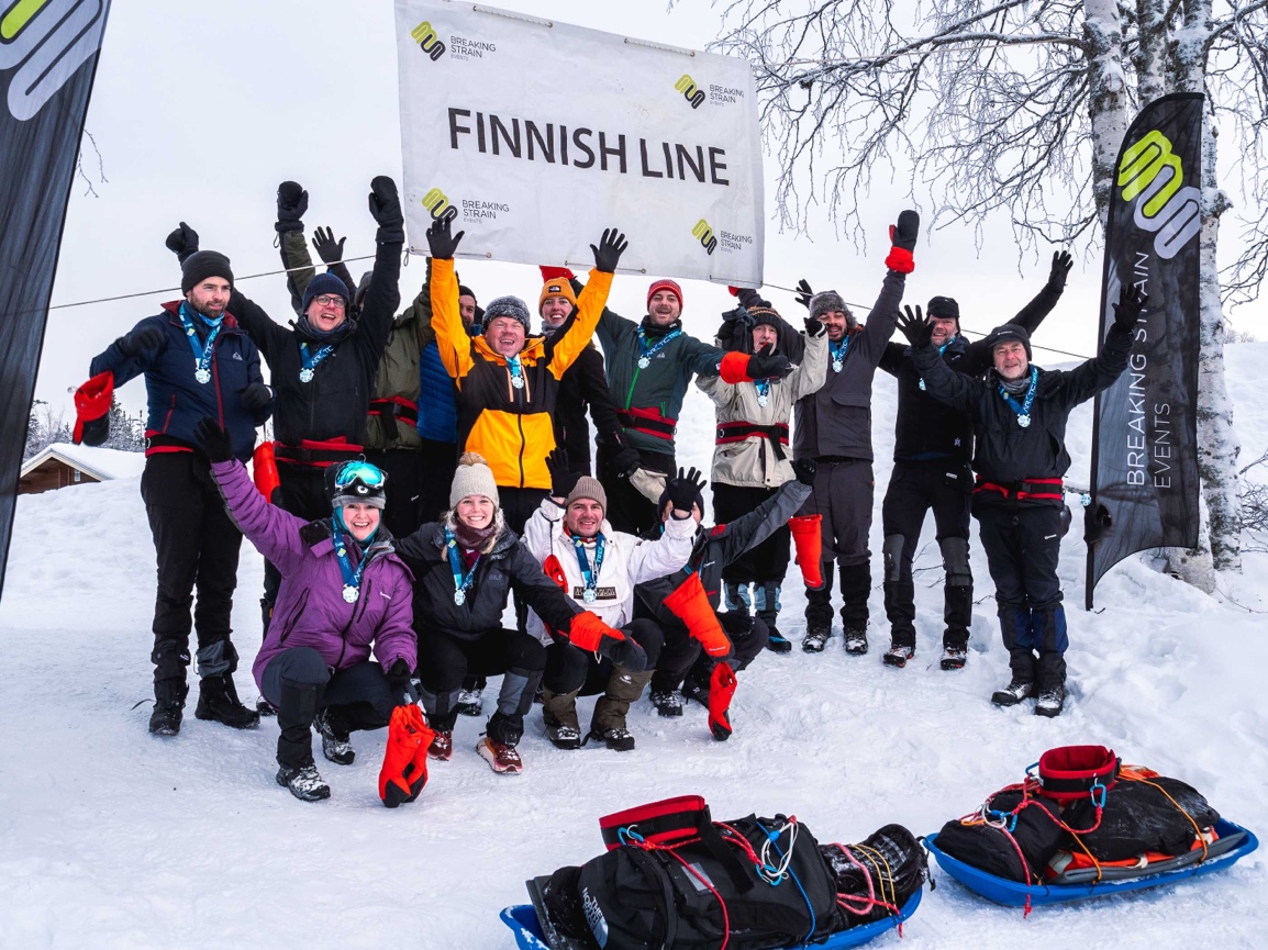 A group of people posing for a photo in the snow

Description automatically generated