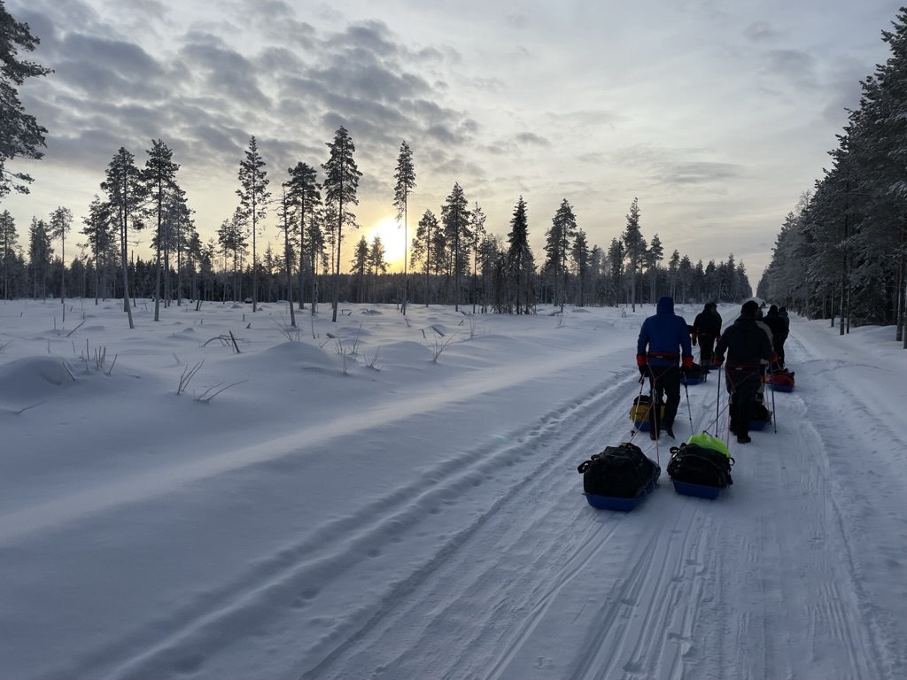 A group of people pulling a sled through the snow

Description automatically generated with low confidence